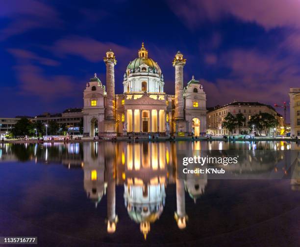 karlskirche church with reflection on water and tourist or people sit around this pond park at night after sunset time in vienna, austria, europe - karlskirche stock-fotos und bilder