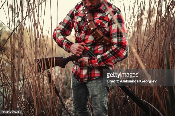hispanic hunter loading riffle - hunting rifle stock pictures, royalty-free photos & images