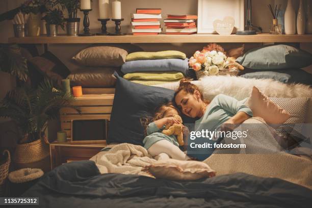 mother reading a book to her daughter - bed time stock pictures, royalty-free photos & images