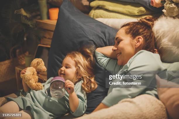 baby girl playing with teddy bear in bed - bedtime stock pictures, royalty-free photos & images