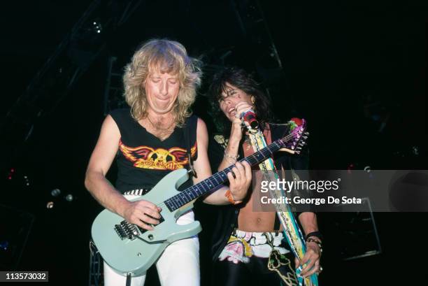 Rhythm guitarist Brad Whitford and singer Steven Tyler performing on stage with American rock group Aerosmith, 1988.