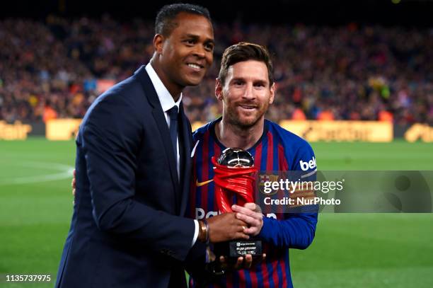 Barcelona's Argentinian forward Lionel Messi receives the Best Player of the Month trophy from Justin Kluivert prior to the La Liga match between FC...