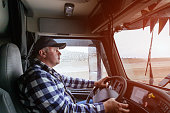 Driver in cabin of big modern truck