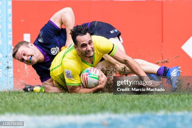 Brandon Quinn of Australia breaks the tackle of Max McFarland of Scotland for scoring his goal during the day three of the Cathay Pacific/HSBC Hong...