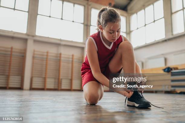 basketball player tying up shoelaces - girls shoes stock pictures, royalty-free photos & images