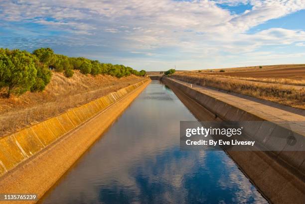 irrigation canal with reflections - estrecho descripción física fotografías e imágenes de stock