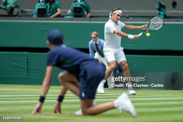 Ball boy watching Roger Federer of Switzerland in action against Adrian Mannarino of France on Centre Court in the Men's Singles Tournament during...