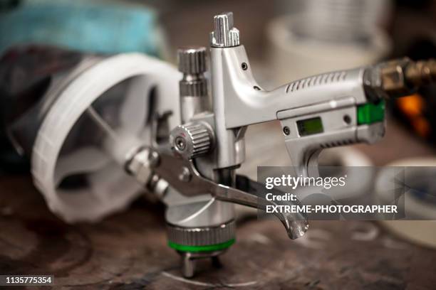 verfspuit pistool liggend op het vulling op de werkbank - compressor stockfoto's en -beelden