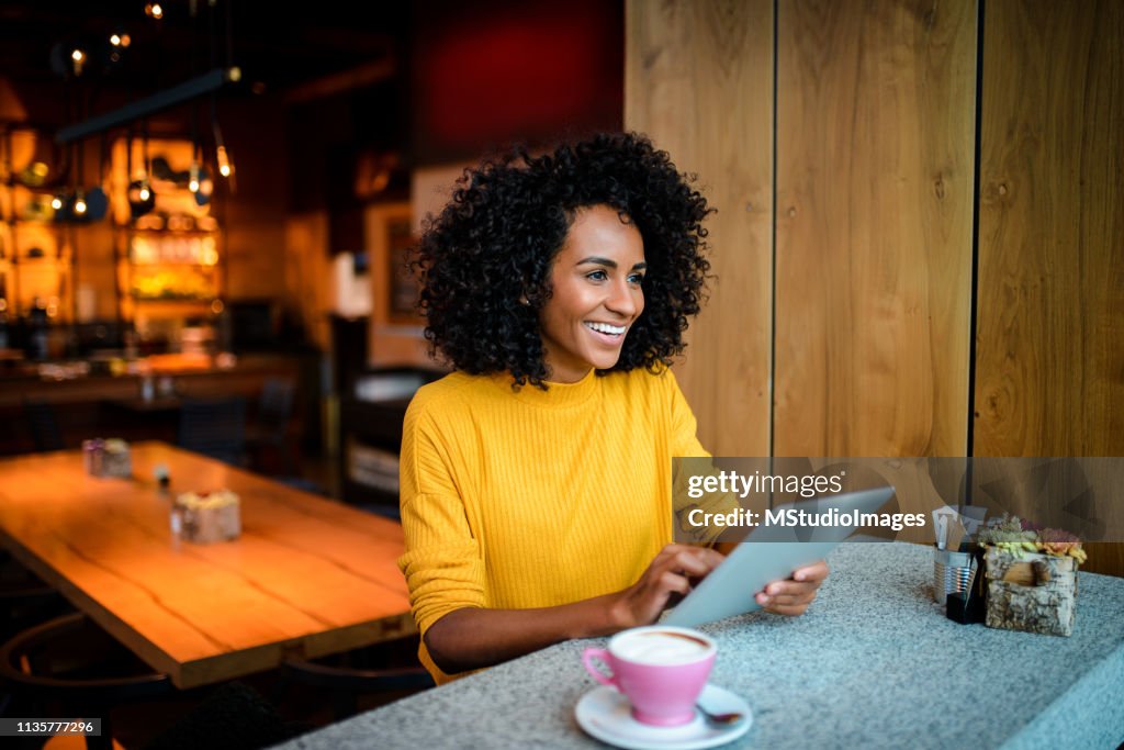 Smiling woman using digital tablet.