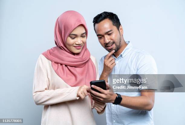 aziatisch maleis paar doen online winkelen op mobiele telefoon - malaysian currency stockfoto's en -beelden
