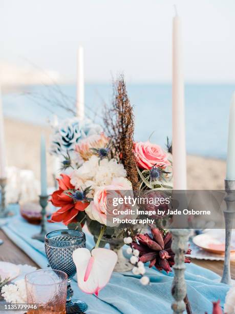 wedding table setting on a beach in santorini with coral wedding flowers - wedding table setting imagens e fotografias de stock