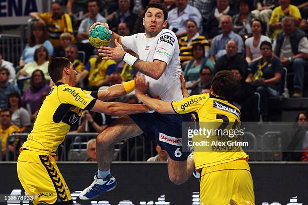 Blazenko Lackovic of Hamburg is challenged by Zarko Sesum and Patrick Groetzki of Rhein-Neckar Loewen during the Toyota Handball Bundesliga match...