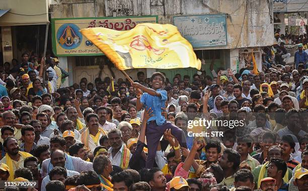 Young supporter of Telugu Desam Party waves a flag as N. Chandrababu Naidu, chief minister of India's Andhra Pradesh state and former Prime Minister,...