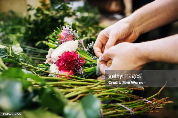 close-up of florist preparing flowers for bouquet - flower shop stock pictures, royalty-free photos & images