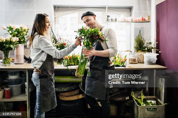 two florists preparing bouquet of flowers - arrangements of flowers stock pictures, royalty-free photos & images