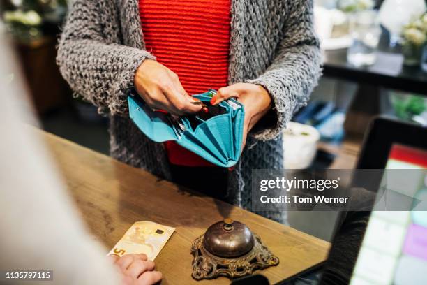 woman paying for flowers at florist - multi colored purse ストックフォトと画像