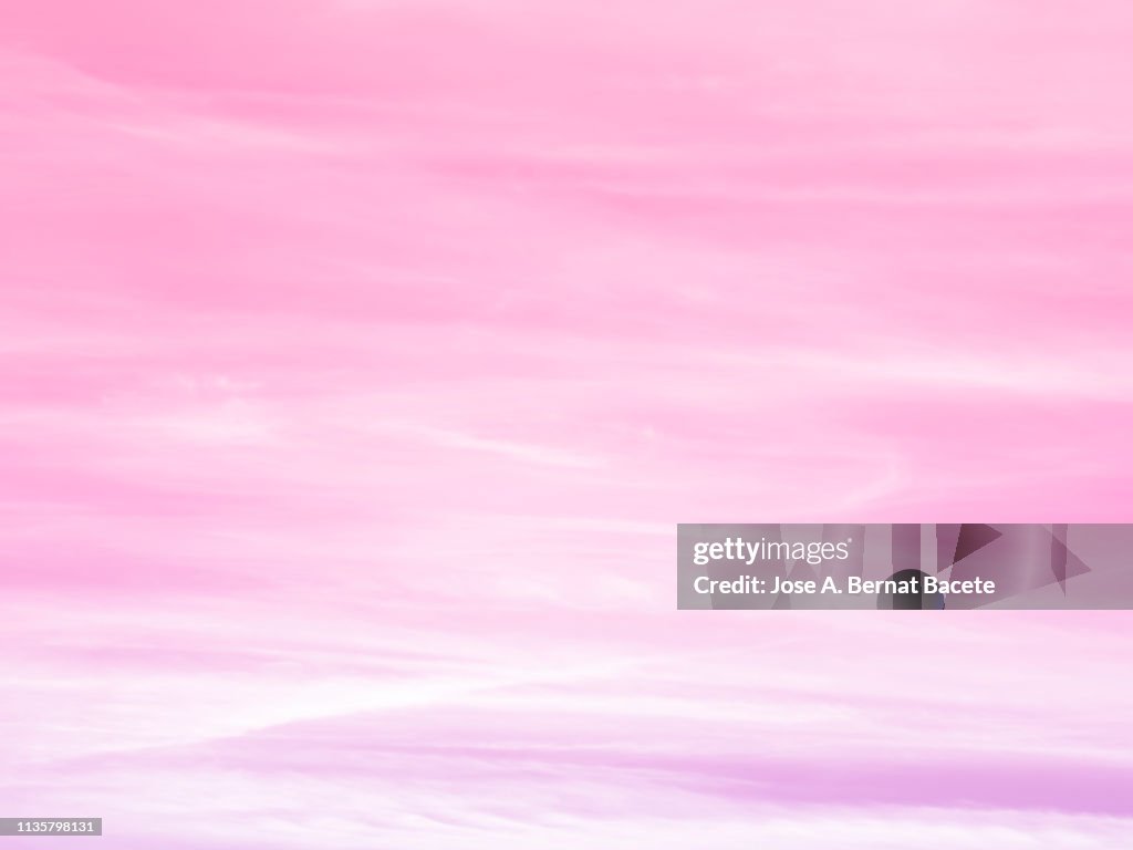 Background of a sky of pale pink color with white clouds.