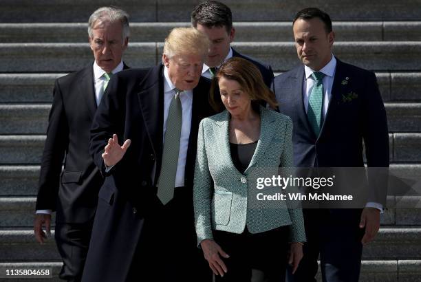 President Donald Trump confers with Speaker of the House Nancy Pelosi while departing the U.S. Capitol following a St. Patrick's Day celebration on...