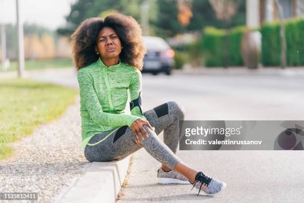 african woman got sport injured while jogging on the street - injured knee stock pictures, royalty-free photos & images