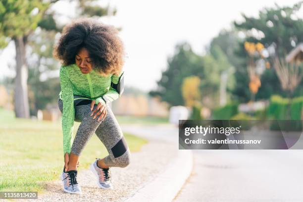 african woman got sport injured while jogging on the street - injured runner stock pictures, royalty-free photos & images