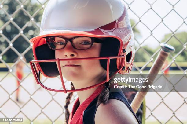 Confident softball player wearing helmet in dugout