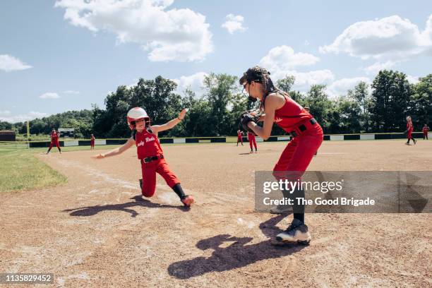 softball player sliding into hoe plate - softball sport stock pictures, royalty-free photos & images