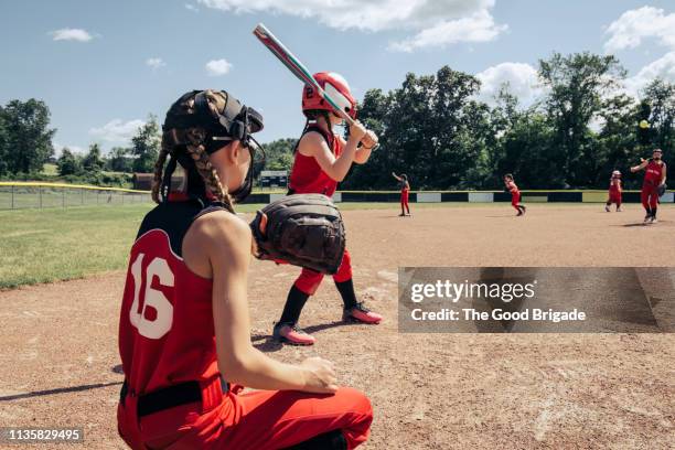 girls softball team practicing on field - batting sports activity - fotografias e filmes do acervo