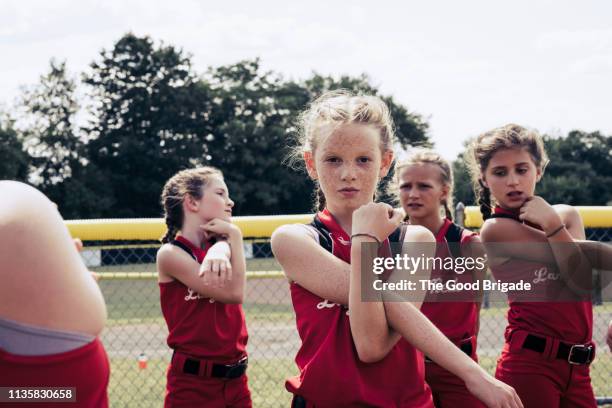 portrait of confident softball player stretching - softball sport stock-fotos und bilder