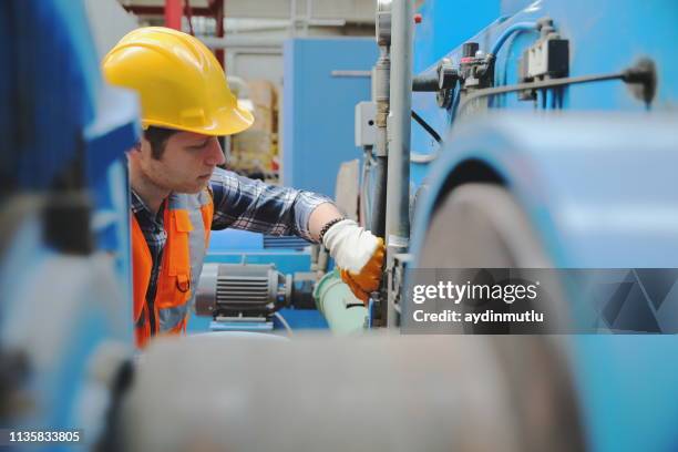 mann arbeitet in einer fabrik - copper coil stock-fotos und bilder