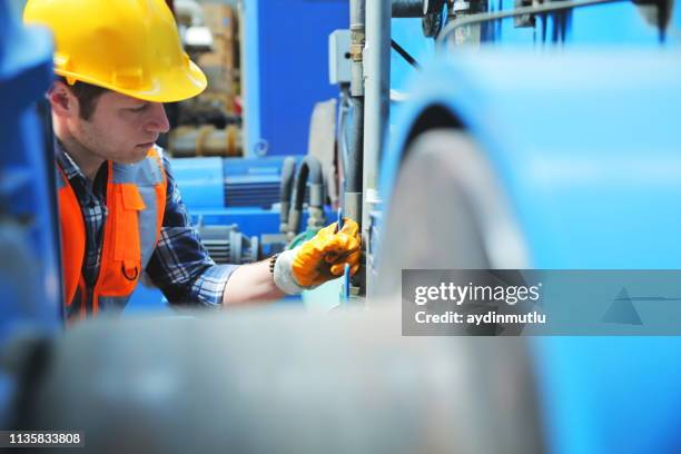 portrait of young manuel worker man working with ball valves in factory - machine valve stock pictures, royalty-free photos & images
