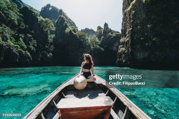 young woman on a longtail boat in thailand, phi phi island - longtail boat stock pictures, royalty-free photos & images