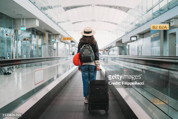 young woman at the airport with a suitcase - arrival departure stock pictures, royalty-free photos & images