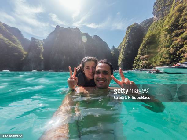 giovane coppia che si fa un selfie nel mare dell'isola di phi phi - thailandia - tailandia foto e immagini stock