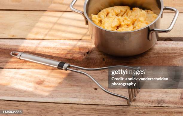 potato and carrot mash - potato masher stock pictures, royalty-free photos & images