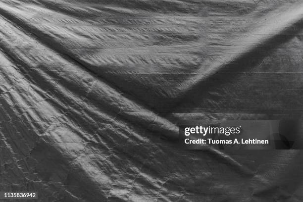 full frame background of a wrinkled tarp texture in black and white. - dekzeil stockfoto's en -beelden