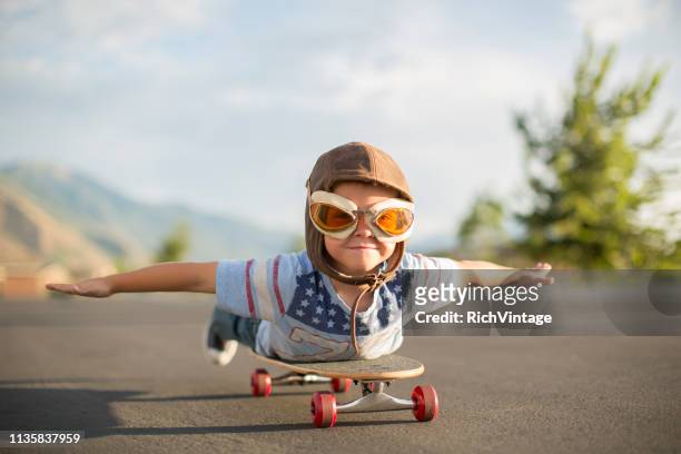 young boy flying auf skateboard - junge träumt stock-fotos und bilder