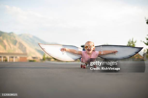 jeune fille volant sur la planche à roulettes avec des ailes - aile de déguisement photos et images de collection