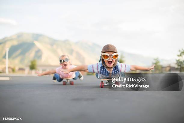 young boy and girl flying on skateboards - the intrepid stock pictures, royalty-free photos & images