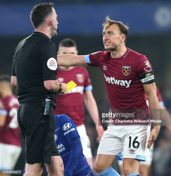 Mark Noble of West Ham speaks angrily with referee Christopher Kavanagh over a yellow card decision during the Premier League match between Chelsea...