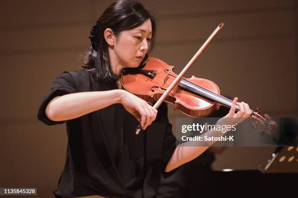 female musician playing violin at classical music concert - beautiful woman violinist stock pictures, royalty-free photos & images