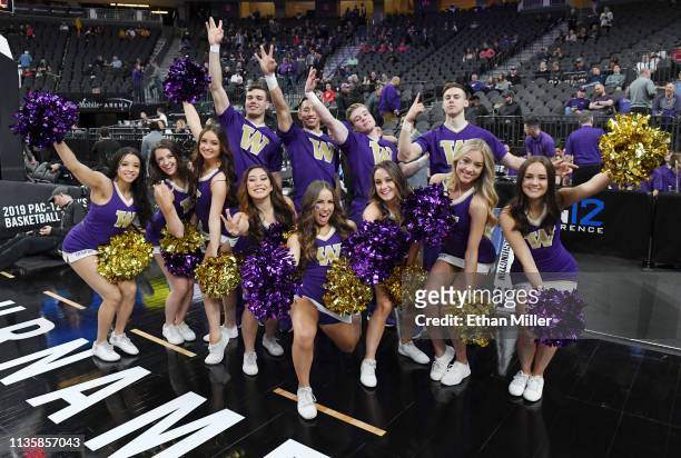 Washington Huskies cheerleaders pose before a quarterfinal game of the Pac-12 basketball tournament against the USC Trojans at T-Mobile Arena on...