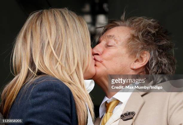 Penny Lancaster and Sir Rod Stewart kiss as they watch the racing on day 3 'St Patrick's Thursday' of the Cheltenham Festival at Cheltenham...
