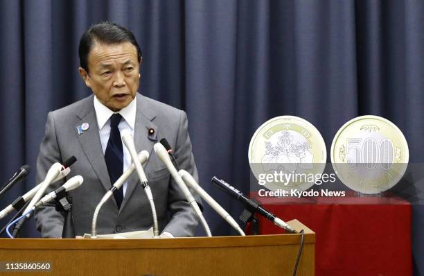 Japanese Finance Minister Taro Aso speaks at his ministry in Tokyo on April 9 about the new 500 yen coin to be introduced in fiscal 2024...