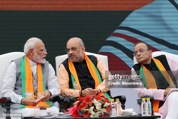Narendra Modi, India's prime minister, left, listens to Amit Shah, president of the Bharatiya Janata Party, as Arun Jaitley, finance minister, looks...