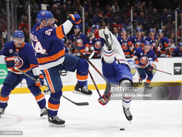 Scott Mayfield of the New York Islanders checks Jesperi Kotkaniemi of the Montreal Canadiens during the third period at NYCB Live's Nassau Coliseum...