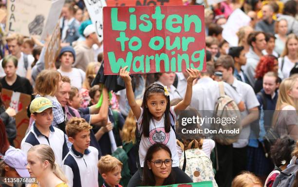 Young girl sits atop her mothers shoulders and holds up a sign during a Climate Change Awareness rally at Sydney Town Hall on March 15, 2019 in...