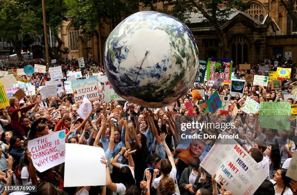 An inflatable planet earth is bounced around the crowd during a Climate Change Awareness rally at Sydney Town Hall on March 15, 2019 in Sydney,...