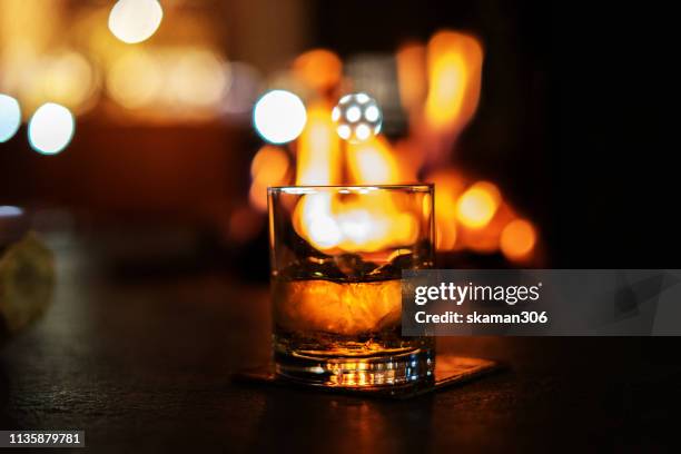 selective focus whiskey glass with bonfire - whisky bar stockfoto's en -beelden