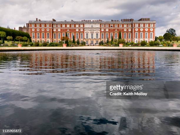 reflection of hampton court palace facade in water fountain. - hampton court palace stock pictures, royalty-free photos & images