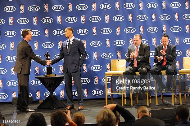 Derrick Rose of the Chicago Bulls is congratulated by Tim Chaney of Kia Motors as Bulls Head Coach Tom Thibodeau and General Manager Gar Forman look...